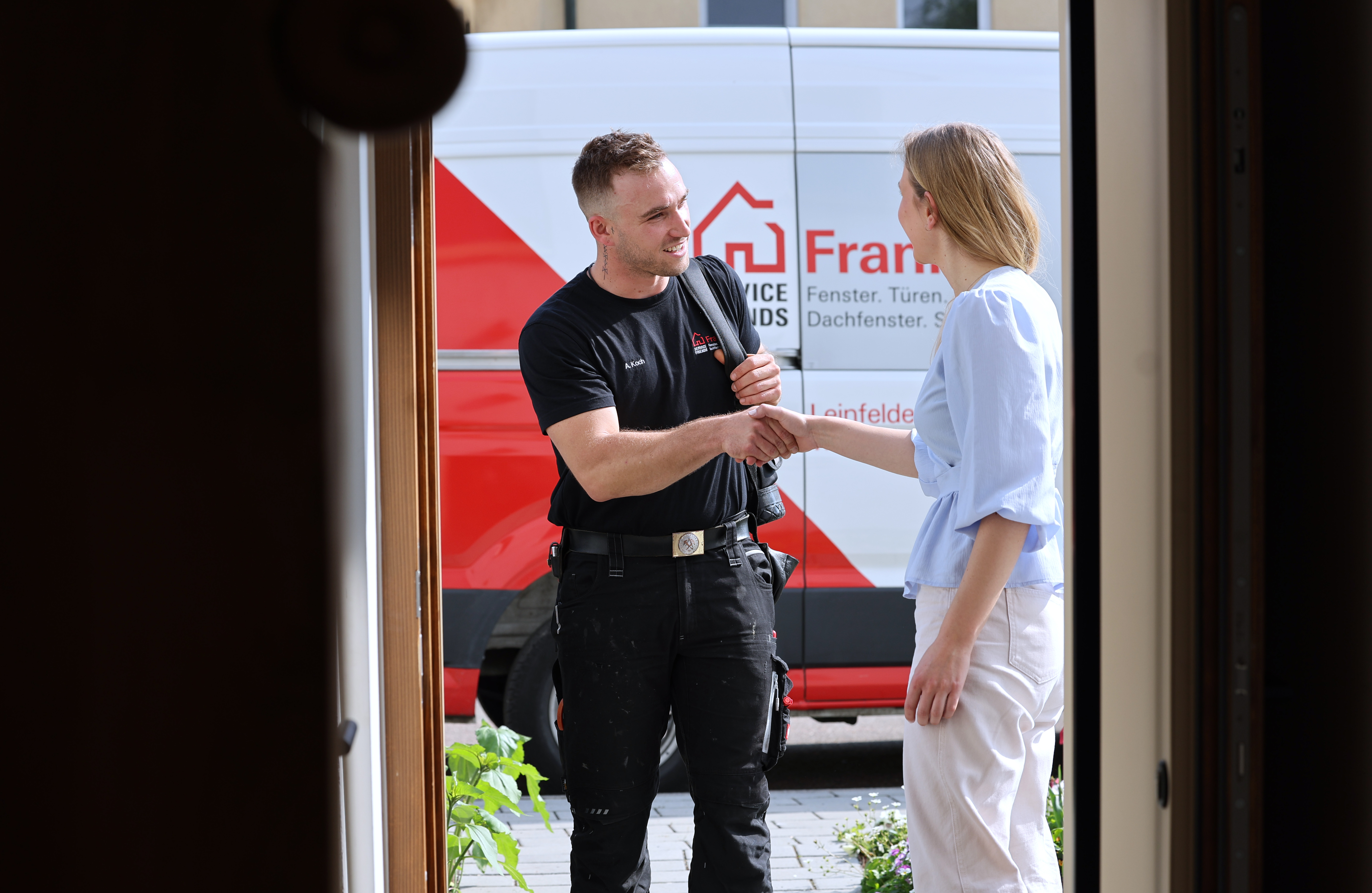 Dachfenster Servicetechniker begrüßt Kundin an der Haustür