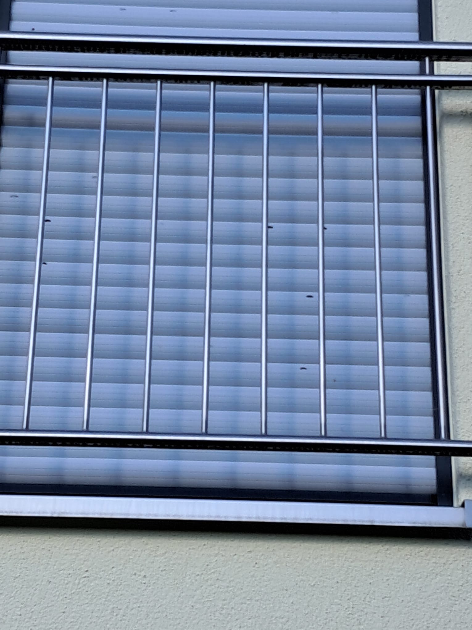 Hagelschaden am Rollladen eines bodentiefen Fensters