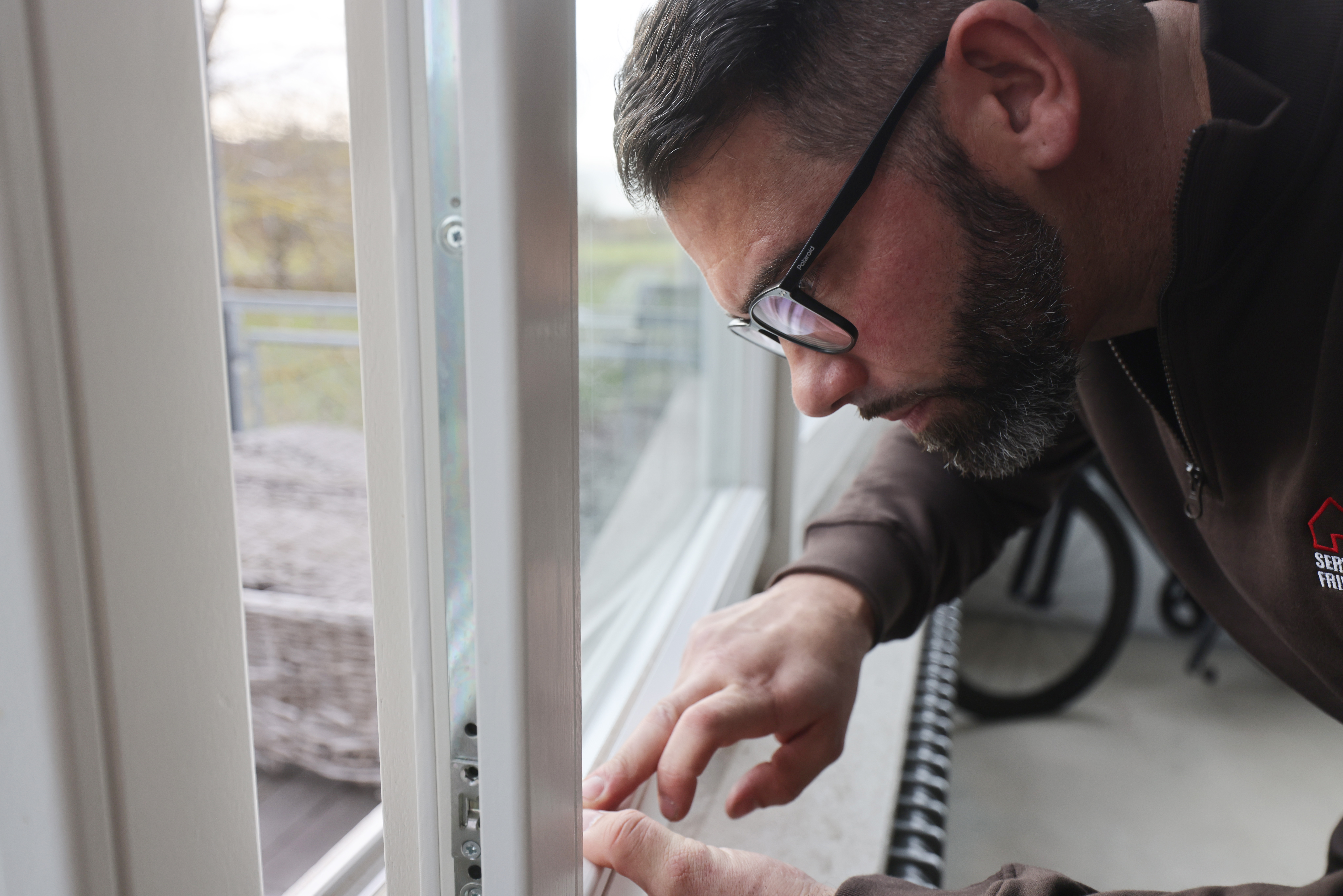 Servicetechniker untersucht Dichtungen eines Fassadenfensters